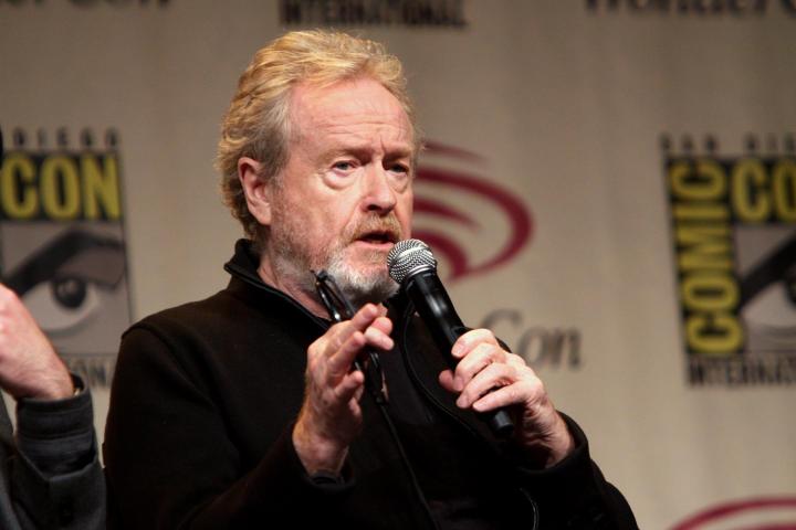 Ridley Scott holds the microphone and speaks.